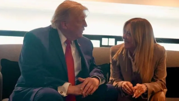 Трамп (ліворуч) і Мелоні, яка широко посміхається, сидять поруч на дивані та спілкуються, нахилившись одне до одного.