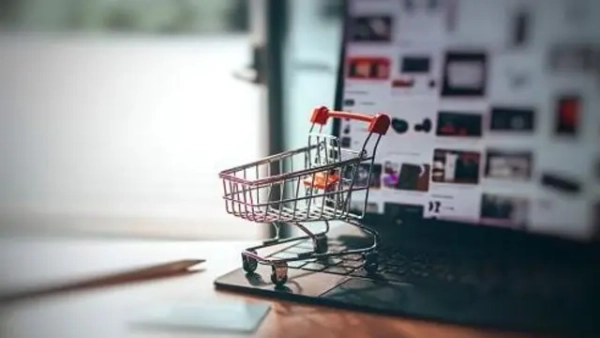 Податки на OLX: Що очікує продавців і покупців на торговельних майданчиках 4 Колаж на тему інтернет-продажів, на клавіатурі ноутбука стоїть мініатюрна корзина на колесах, як у супермаркетах