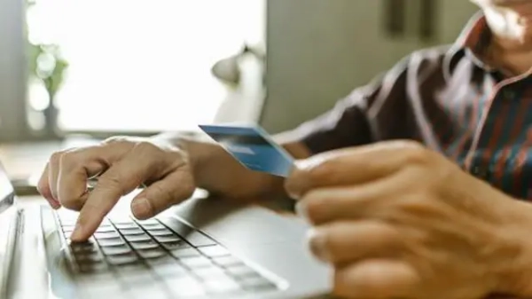 Податки на OLX: Що очікує продавців і покупців на торговельних майданчиках 3 Колаж, на якому чоловік тримає в руці банківську картку і друкує на клавіатурі ноутбука
