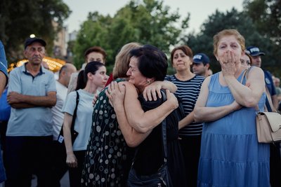 Жінки, переселенки з карабаського регіону, обіймаються та плачуть під час мітингу в Єревані 2 вересня 2025 року. Учасники зібрання відзначали 34-ту річницю проголошення незалежності Нагірного Карабаху у 1991-му