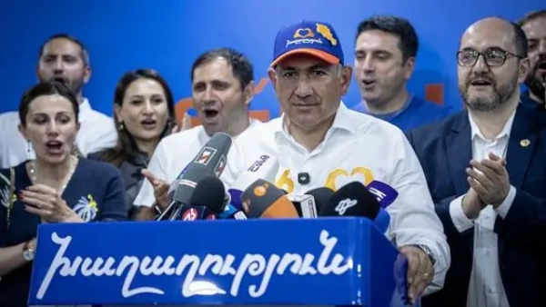Прихильники Євросоюзу, на яких нарікає Путін, здобувають переконливу перемогу на виборах у Вірменії 4 Нікол Пашинян у колі своїх прихильників, стоїть за трибуною, у блейзері кольорів національного прапора Вірменії