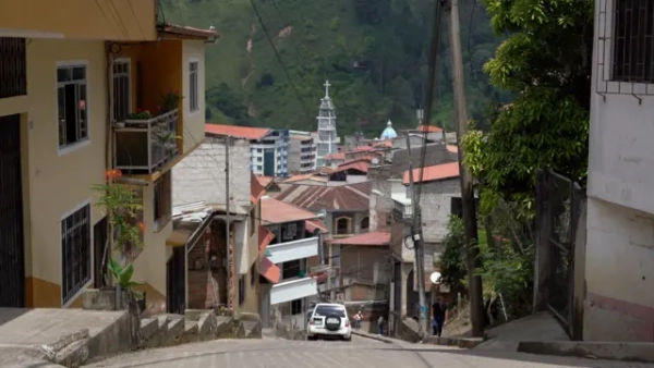 Фото Піньяса, зняте з верхівки крутого пагорба; видно будівлі по боках та зелений гірський схил на відстані