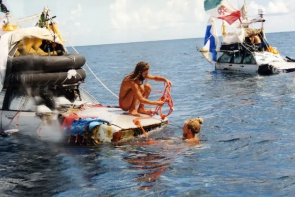 Два автомобілі 1970-х років плавають у морі. На дахах - прапори, вітрила та надувні човни. Один чоловік зі світлим волоссям (Марко Аморетті) перебуває у воді, тримаючись рукою за капот. Інший, із темним волоссям і бородою (Марко Де Кандіа), сидить навпочіпки на капоті того самого автомобіля, поки вони ремонтують прив’язану до нього мотузку.