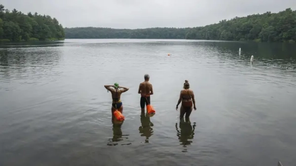 Люди стоять у воді на березі озера