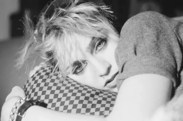 На чорно-білому промофото Мадонни 1982 року співачка лежить на картатій подушці й дивиться просто в камеру