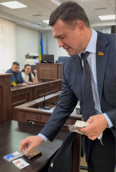 "Ось так буде", – каже журналістам Тищенко, розкладаючи фото своїх дітей та ікону на столі, імітуючи їхню розстановку у камері СІЗО