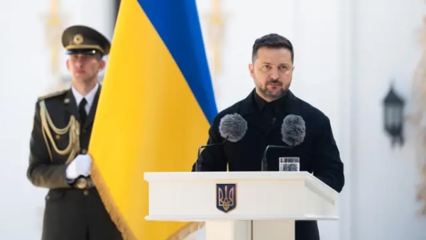 Зеленський та Навроцький провели зустріч в Анкарі. Деякі деталі. 8 Зеленський за білою трибуною з гербом України та виступає перед мікрофонами; позаду видно великий синьо-жовтий прапор і військового у формі, який стоїть на варті.