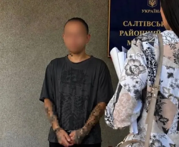 Чоловік у кайданках, обличчя заблюрене 
