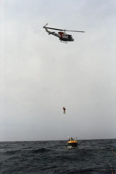 Гелікоптер завис над автомобілями в морі, піднімаючи двох чоловіків 