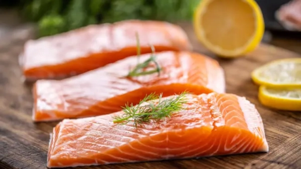 10 чудових продуктів для пам'яті 11 Сире філе лосося на дерев’яній дошці з кропом, розмарином і лимоном.