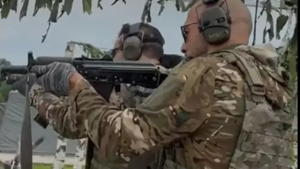 Ендрю Тейт стріляє з автомата.