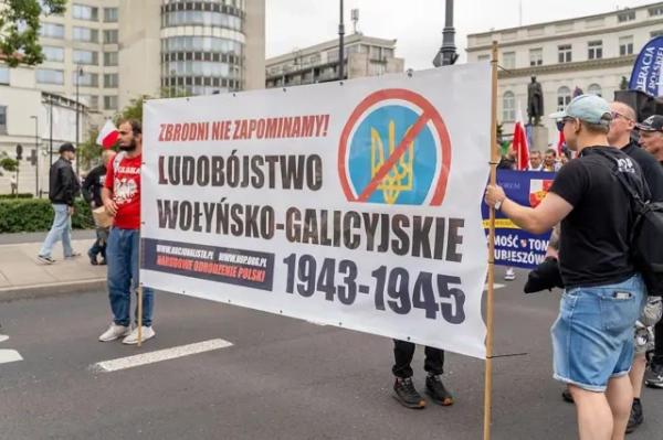 У Польщі чоловік ображав українських дітей в автобусі. Обидві країни втрутилися міністрами. 4 Протестувальники несуть банер з написом «Волинсько-галицький геноцид 1943-45» із зображенням перекресленого українського тризуба під час демонстрації у Варшаві, Польща, 12 липня 2026 року. (Фото Марека Антонія Іванчука/NurPhoto via Getty Images)