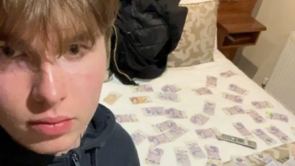 Молодий світловолосий чоловік на фоні столу, де лежать гроші