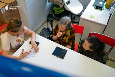 Працівниця благодійного фонду Uniters спілкується з українськими переселенками, які звернулися по допомогу. Варшава, 15 липня 2026 року