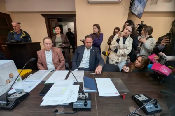 Єрмак та Хартія. Як інтеграція корпусу до програми "Адвокат+" викликала хвилю дискусій 8 У залі засідань за столом із мікрофонами сидять Єрмак і Фомін перед паперами. Позаду й праворуч — група журналістів з камерами та телефонами, спрямованими на них. На столі видно документи, телефон і обладнання для запису звуку, у фоні — двері та люди біля входу.