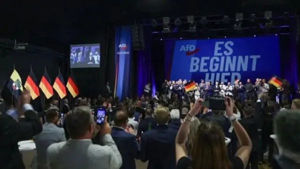 Захід прихильників партії "Альтернатива для Німеччини" (AfD). На сцені та на екрані видно символіку партії та напис "ES BEGINNT HIER" ("Це починається тут").